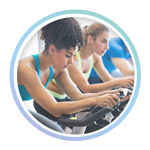 close up photo of women riding a spin bike