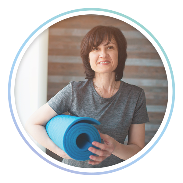 photo of woman holding a rolled up yoga mat